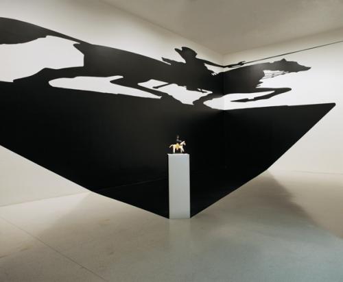 Silveira Regina: A szent paradoxona 1994, (installáció, posztamens, fafigura, öntapadós vinilkivágás, árnykép-sziluett): Regina Silveira és MAC/USP Collection Museum of Contemporary Art / University of Sao Paulo gyűjteménye. Fotó: Mauro Restiffe